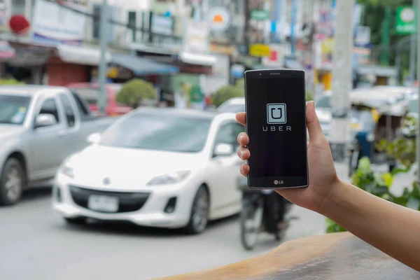 Chiang Mai, Tayland - 17 Temmuz 2016: Lg G4 üzerinde yol ve beyaz araba üzerinde gösterilen Uber app tutan bir adam el Uber smartphone app tabanlı ulaşım ağıdır.