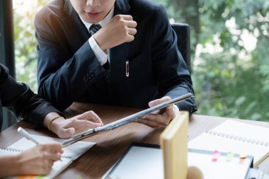 Fon yöneticileri takım danışmanlığı ve dijital tablet üzerinden yatırım borsası analizi hakkında tartışmalar.