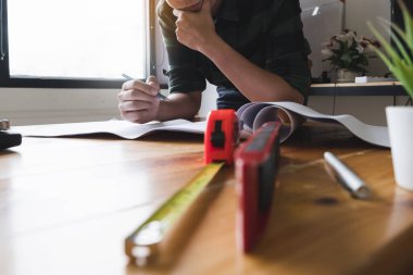 Mimarlık planı için pusula ve planlarla çalışan mimar, bir inşaat projesi konsepti çizen mühendis..