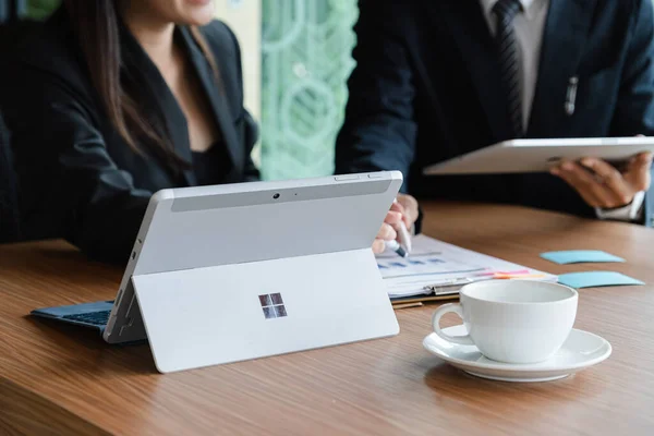 CHIANGMAI, THAILAND - 31 AUG 2019: Microsoft Surface tableti iş adamı ve iş kadınlarıyla birlikte masanın üzerinde. Microsoft tarafından Windows 10 için oluşturuldu.