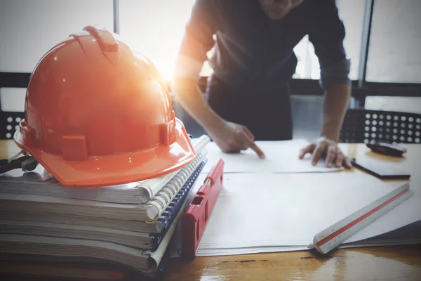 Interior Architect with blueprint for architectural plan, engineer sketching a construction project concept in engineer office.