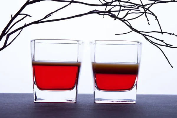 Beyaz zemin üzerinde bir içkiyle gözlük