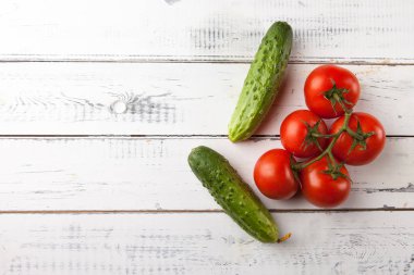 Taze organik domates ve salatalık Beyaz ahşap masa, üstten görünüm üzerinde. Kopya alanı.