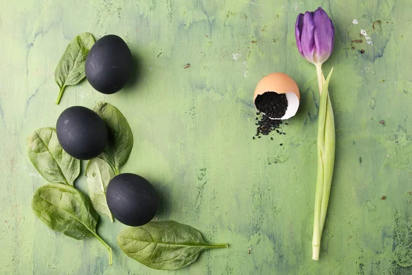 Siyah yumurta ve yeşil zemin üzerine susam ile Lale çiçek. Sağlıklı beslenme kavramı.