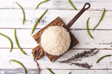 Demir güveç ahşap kesme tahtası, üstten görünüm üzerinde yeşil fasulye ile pirinç