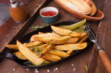 Ahşap arka planda ketçaplı patates kızartması. Kapat.