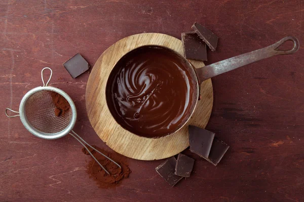 Ahşap arka plan üzerinde tavada eritilmiş çikolata girdap