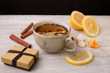 Bardak bitkisel çay ve hediye kutusu ahşap arka plan üzerinde. Yakın çekim