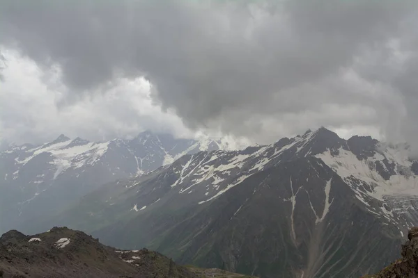 Picos rochosos com neve nas nuvens, região Norte do Cáucaso Elbrus . — Fotografia de Stock