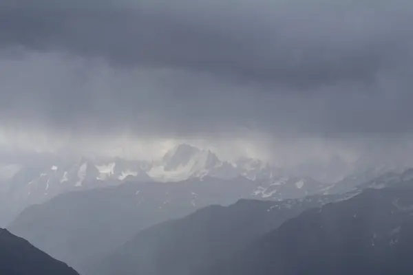 雲で隠されて雪をかぶった山頂北コーカサス、ロシアのエルブルス山の斜面からの眺め. — ストック写真