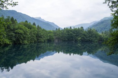 Mavi göle orman ve dağlar yansıtır.