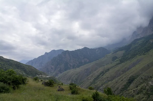 Bulutlarda saklanıyor eteklerinde dağ yolu — Stok fotoğraf