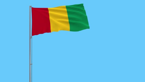 Aislar Bandera Guinea Asta Bandera Ondeando Viento Sobre Fondo Azul — Vídeo de stock
