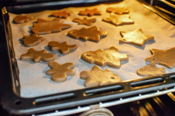 Vlose-up vista parcial de la persona poniendo galletas de Navidad en el horno —  Fotos de Stock