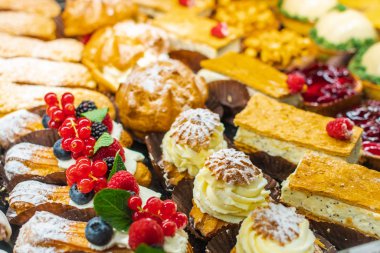 Çeşitli donutları, kekleri, creme brulee 'si, meyveli pastaları ve meyveleri olan bir pastane.