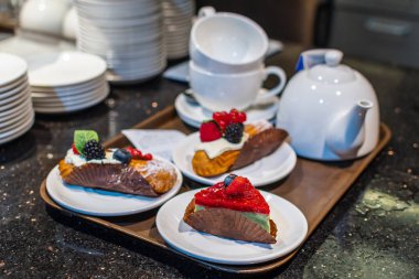 Pastry with coffee and some pastry in cafe in tray. Ready to eat.