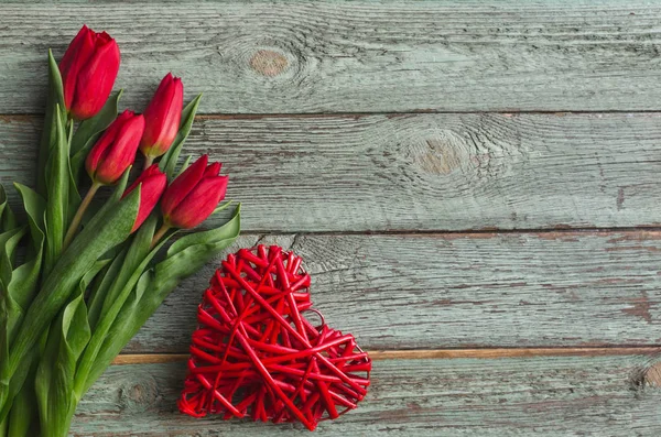 Tulipanes rojos con corazón sobre fondo de madera. Concepto de San Valentín — Foto de Stock