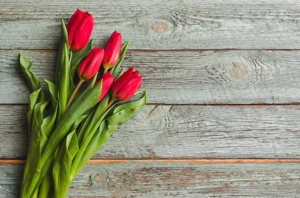 Tulipanes rojos sobre fondo de madera. Concepto de San Valentín. 8 de marzo. Concepto del día de madre. Vista superior . — Foto de Stock