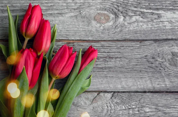 Tulipanes rojos sobre fondo de madera. Concepto de San Valentín. 8 de marzo. Concepto del día de madre. Vista superior . — Foto de Stock