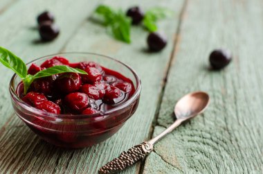 Bir kase kiraz reçeli ve taze kirazlı, ev yapımı reçelli. Seçici odak.