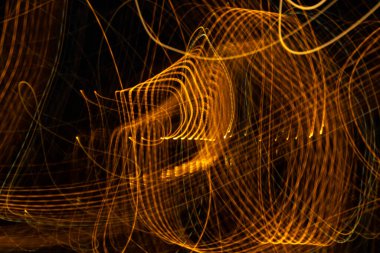 Altın renkli resim, uzun pozlu fotoğraf altın renkli ışıkların siyah arka planda bir döngü oluşturması..