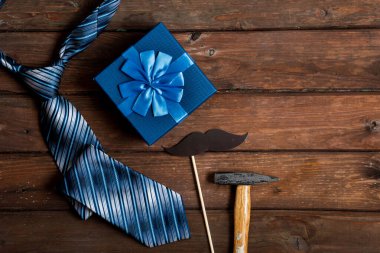 Babalar Günün kutlu olsun. Kravat, çekiç, mavi kulübe ve kır ağacından yapılmış bıyıklı hediye paketi. Metin için boşluk.