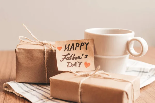 Gift box with a tag, cup of coffee or tea. Fathers day or birthday concept. — Stock Photo, Image