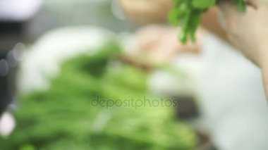 Mutfak işçileri taze otlar seçin ve demetleri toplamak.