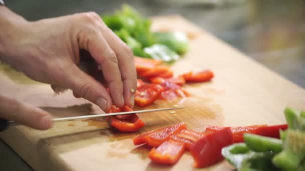 Chef schneidet roten grünen Pfeffer auf Schneidebrett in Industrieküche — Stockvideo