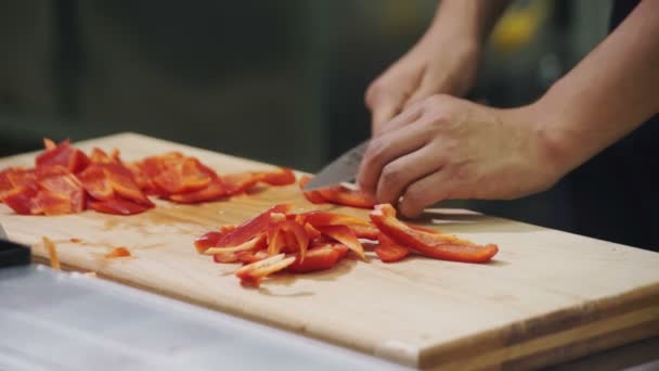 Chef-kok snijdt de rode peper op snijplank in industriële keuken — Stockvideo