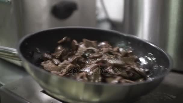 Főzni a húst egy serpenyőben, spatula és dobálhat a levegőben. — Stock videók