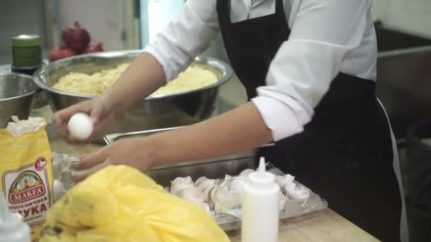 На кухне шеф-повар отделяет белки от желтков яиц. . — стоковое видео