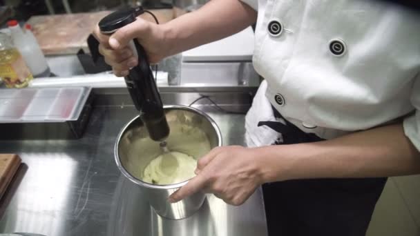 Chef crème fouettée avec fouet mélangeur remplissage à l'intérieur restaurant . — Video