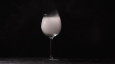 Şeffaf cam siyah bir arka plan üzerinde beyaz duman dağınık.