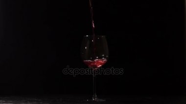 Kırmızı şarap ile dolu karanlık boş şeffaf cam.