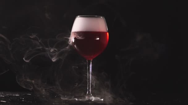 Instalación de humo en vidrio con vino sobre fondo negro — Vídeos de Stock