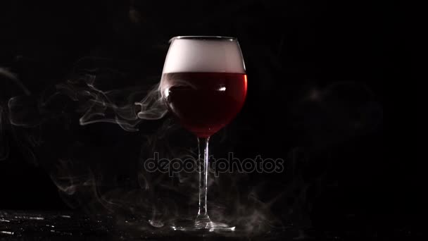 On a black background with glasses of red liquid coming out steam. — Stock Video