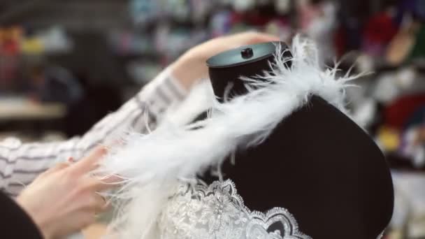 Mujer seleccionar accesorios a vestido blanco en el maniquí para una mejor imagen . — Vídeo de stock