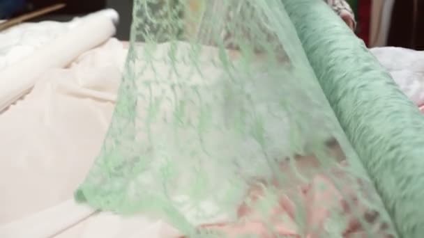 Woman examine roll of transparent material on special table. — Stock Video