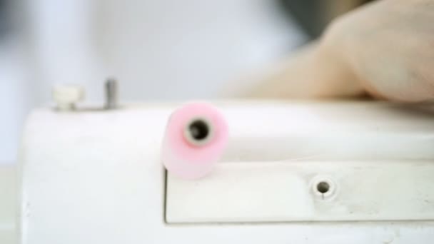 Primo piano mani di tiro mettendo filo rosa nella macchina da cucire — Video Stock