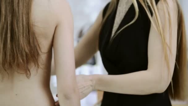 Blonde naaister neemt metingen vrouw voor het naaien — Stockvideo