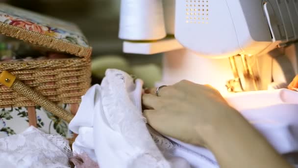 Naaister naait satijn stof op overlock binnen atelier — Stockvideo