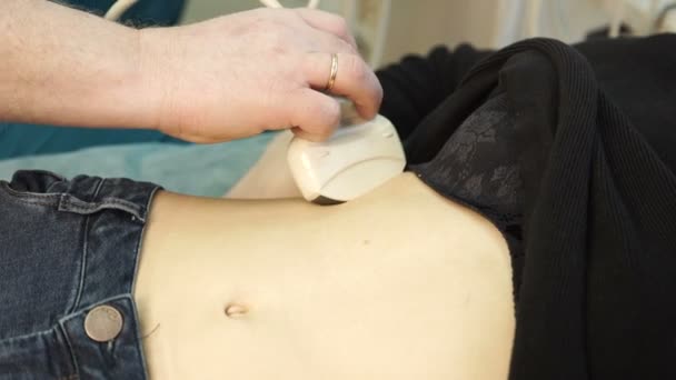 The doctor moves the ultrasound sensor over the abdomen to the patient — Stock Footage The doctor moves the ultrasound sensor over the abdomen to the patient Royalty Free Stock Video