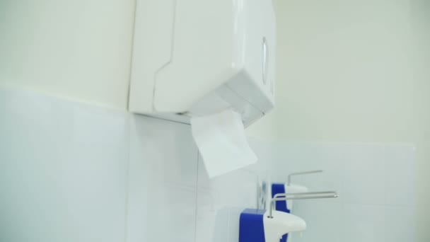 El médico se limpia cuidadosamente las manos con una servilleta sobre el fregadero. . — Vídeo de stock