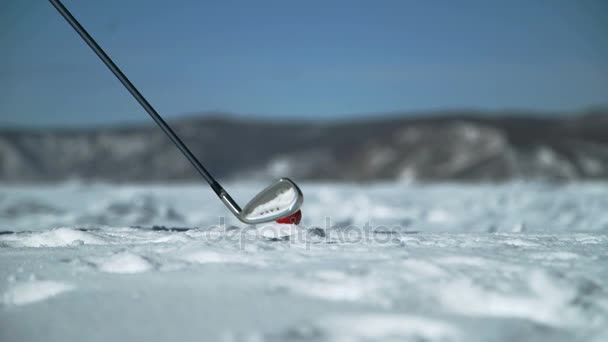 Человек играет в гольф на снегу в зимней окружающей среде — стоковое видео
