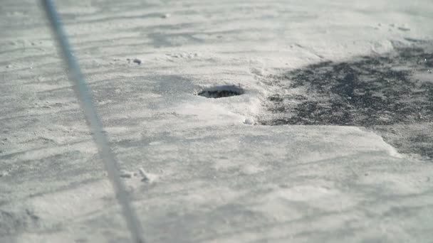 Al jugar al golf, la bola naranja cae en el agujero de nieve . — Vídeo de stock