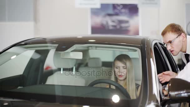 Slow motion shot of woman sitting at wheel of car in center — Stock Video