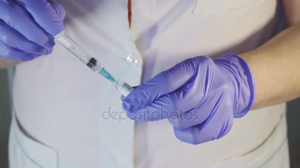 Jonge verpleegster vullingen wegwerp injectiespuit met geneeskunde binnenshuis. — Stockvideo