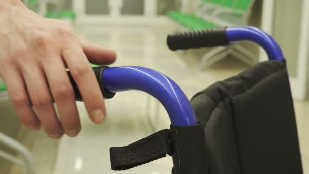 Genç adam tekerlekli sandalye Travmatoloji bölümünde taşır. — Stok video