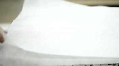 Üretim minder için fabrikada bir çalışan beyaz bir bez ile bahar birim tutar..